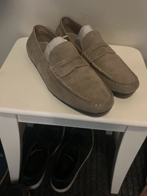 Beige mocka loafers - Beiga mocka loafers från H&M i näst intill oanvänt skick. 