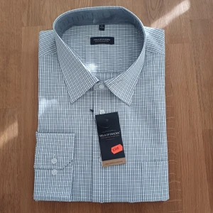 Rutig skjorta från Eton of Sweden - Klassisk rutig skjorta från Eton of Sweden i vitt och blått. Skjortan har lång ärm, knappar framtill och en snygg krage. Tillverkad i mjuk bomull som känns skön mot huden. Perfekt för dig som gillar stilrena och tidlösa plagg.