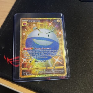 Electrode Pokémonkort Secret Rare - Säljer ett Electrode Secret Rare Pokémonkort med guldglittrig holografisk yta. Kortet har el-typ och coolt motiv med Electrode i blått och vitt. Kortet är inplastat i skyddsfodral och har samlarkänsla för Pokémonfans.