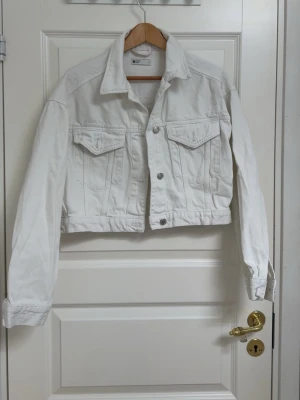 Vit jeansjacka - En vit jeansjacka från Ginatricot. Den är lite croppat därför den ser kort ut. 