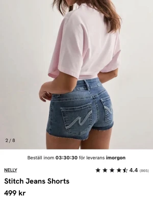 Blå jeansshorts med kontrastsömmar Nelly - Säljer ett par blå jeansshorts från Nelly med råa kanter och kontrastsömmar på bakfickorna. Shortsen har medium midja och dragkedja med två knappar. Perfekta till sommaren💗Aldrig använda och säljer för att de är för små. I storlek 34, skriv om frågor 💗