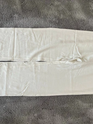 Vita linnebyxor från BIANCA Nelly - Säljer ett par vita linnebyxor från BIANCA Nelly. Byxorna har rak passform och resår i midjan för extra komfort. Tillverkade i ett lätt och luftigt linnematerial som passar perfekt till sommaren. Superenkla att matcha med olika toppar!