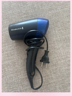 Blå och svart hårfön Remington - Säljer en kompakt hårfön från Remington i blått och svart. Hårfönen har vikbart handtag och sladd med EU-kontakt, perfekt för resor eller hemma. Tillverkad i plast och har en stilren design.