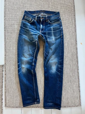 Selvedge jeans från Nudie Jeans - Säljer ett par mörkblå jeans från Nudie Jeans med selvedge material i modellen gritty jackson. Lagning i skrevet. Sjukt fet tvätt som bara blir bättre med användning. Strl W29 L32