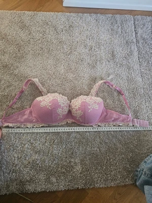 Rosa bh med spetsdetaljer från intimissimi  - Säljer en rosa bh med snygg vit spets upptill på kuporna. !!Den är insydd så den är ish 63 runt istället för 75-80!! Så den passar som en 70D/65E men är som en 80B i kupan så mät gärna innan 