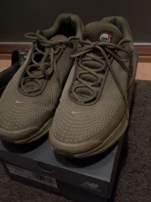 Nike Air Max Plus Olive sneakers - Snygga Nike Air Max Plus sneakers i olivgrönt med diskreta vita detaljer. Skorna har en sportig design med synlig Air-dämpning i sulan och meshmaterial på ovandelen för bra andningsförmåga. Perfekta för dig som gillar streetwear och vill ha en unik look.