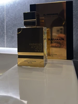 Al Haramain Amber Oud Gold Edition - Lyxig parfym i en elegant, fyrkantig flaska med guldfärgad design och svart lock. Al Haramain Amber Oud Gold Edition har en exklusiv look och rymmer 120 ml. Perfekt för dig som gillar orientaliska dofter och snygg förpackning.