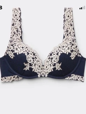 Intimissmi push up - Snygg mörkblå bh med vit spets och blommönster på kupor och axelband. Bh:n har formpressade kupor och dekorativa spetsdetaljer som ger en elegant look. Perfekt för dig som gillar stilrena och romantiska underkläder.