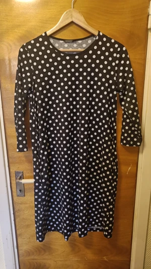 Svart prickig klänning med trekvartsärm - Svart/vit prickig klänning från Marimekko, strl xs. Fint skick. Bomull.  Katt finns i hemmet.