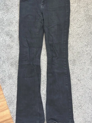 Svarta bootcut jeans från ONLY - Säljer ett par svarta bootcut jeans från ONLY. Jeansen har klassisk femficksdesign, dragkedja och knapp framtill. Materialet är stretchigt denim som sitter snyggt och bekvämt. Perfekta för dig som gillar en bekväm och snygg outfit 