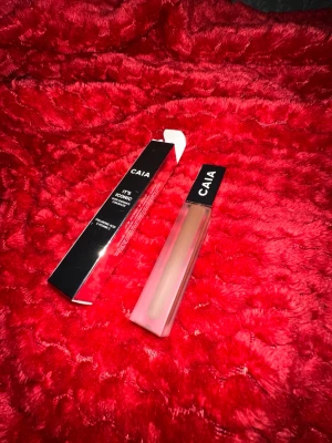 CAIA It's Iconic Concealer - Säljer en CAIA It's Iconic Satin Radiance Concealer. Kommer i en snygg, fyrkantig tub med svart lock och frostad finish. Färgen är en ljus beige ton, perfekt för att ljusa upp under ögonen eller täcka ojämnheter. Innehåller hyaluronsyra och vitamin C.
