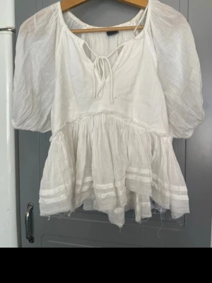 Vit sommar blus  - Väldigt festlig blus med tunt material vilket är perfekt till varma sommardagar när man vill ha på sig något finare. Tyvärr har den missfärgningar som jag hoppas går bort med något slags medel som Vanish. Har själv skrubbat med bara vatten för jag inte har något medel hemma.