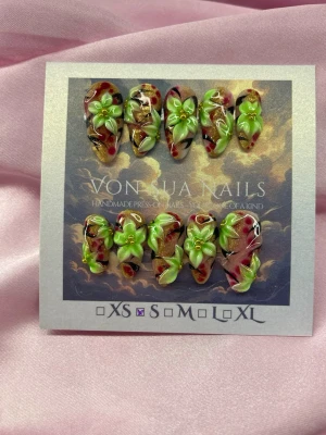 ToxicBloom (S);Medium Almond - Unika Handgjorda press-on naglar med handgjorda 3D-blommor i limegrönt och gult på en bakgrund av svart, rött och guld. Naglarna har en medium lång mandelform och en glansig finish. Perfekt för dig som vill sticka ut med unika och kreativa naglar.S: 15 mm, 11,5 mm, 12 mm, 11 mm, 9 mm 
