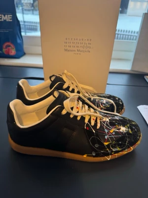 Maison Margiela sneakers med färgstänk - Säljer ett par feta margiela gats i nyskick! endast haft på få gånger! Pris kan självklart diskuteras