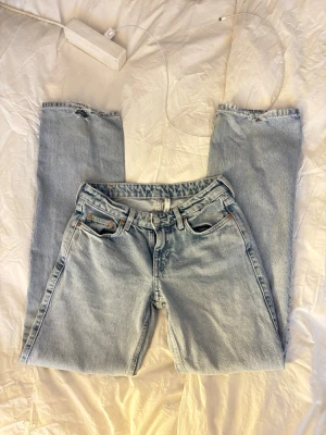 Ljusblå lågmidjade raka jeans - Säljer ett par klassiska ljusblå jeans med raka ben och låg midja. Lite slitna vid baksidan av ben sluten, men det ger en cool touch😊