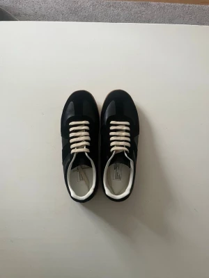 Maison Margiela gats  - Tjena, säljer ett par svarta Maison Margiela gats i storlek 43. Ett par stilrena sneakers som passar både till en avslappnad och uppklädd stil. Skorna är i mycket bra skick. Hör av dig om du har några frågor eller funderingar 😁 /Filip                                   