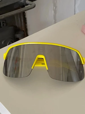 Sportiga gula solglasögon - Coola solglasögon. Ramen är i en stark gul färg och glasögonen har en modern, futuristisk look. Perfekta för dig som vill sticka ut med en färgglad accessoar. 