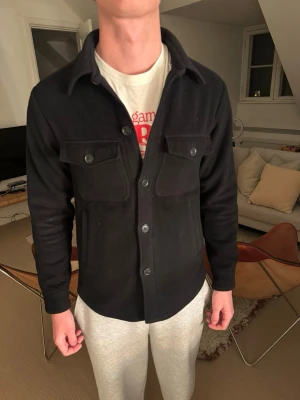 Svart overshirt med bröstfickor - Säljer en snygg svaet jacka då den inte kommer till användning. Använd ett fåtal gånger. Funkar bra till både hösten och våren. Pris kan diskuteras 