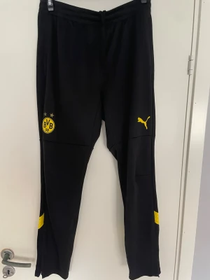 Borussia Dortmund Träningsbyxor - Borussia Dortmund Träningsbyxor i storlek L. Använt ett par gånger med omsorg, knappast några defekter. Om du har några frågor, hör gärna av dig. 