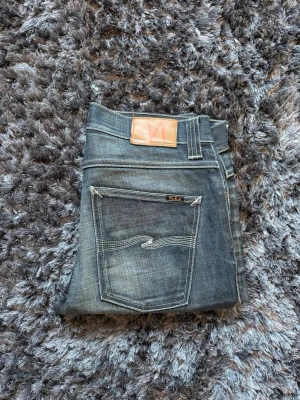 Vintage Nudie jeans - Snygga grim tim slim fit jeans från Nudie. 33/32 men sitter som 32/32. Midja 42cm och ytterbenlängd 106cm. Modellen är 72kg 183cm