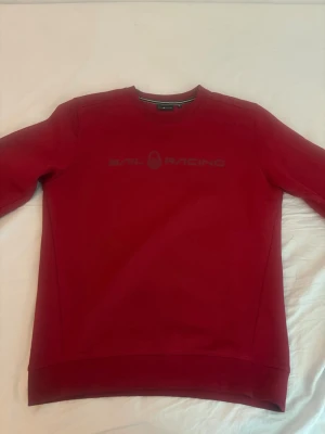 Sail Racing hoodie - Röd sail racing hoodie använd ett par gånger i väldigt bra skick storlek M.