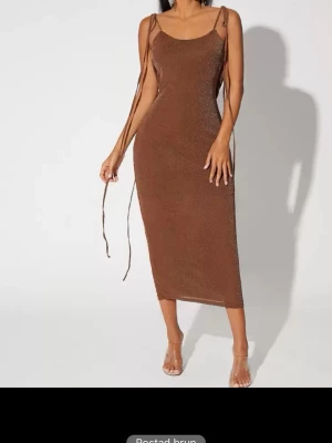 SHEIN klänning  - Trendig brun långklänning med smala axelband och snygga snörningsdetaljer. Klänningen har öppen rygg och är figurnära med en lätt glittrig finish. Perfekt för dig som vill sticka ut med en elegant och modern look.