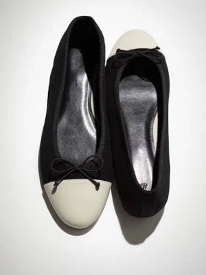Svarta ballerinaskor med beige tå - Stilrena ballerinaskor från H&M i svart tyg med beige tåparti och liten rosett framtill. Skorna har rundad tå och klassisk form, perfekta för en trendig och enkel look.
