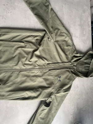 Olivgrön Under Armour Windbreaker - Olivgrön Under Aromour windbreaker, använts 3 gånger. Är i väldigt bra skick.