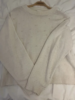 Vit stickad tröja med pärlor - Mysig vit stickad tröja med pärlor på framsidan. Gammal hm model i storlek XS