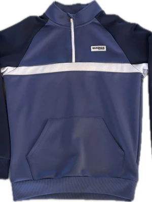 Blå sportig topp och tröja McKenzie - Säljer ett set från McKenzie med en blå långärmad tröja med half zip och en matchande kortärmad topp. Byxor med snygg detaljer. Båda har vita detaljer och sportig design med logga framtill. Perfekt för en avslappnad och cool stil.