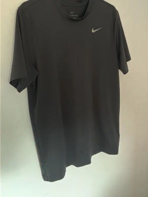 Svart Nike t-shirt i funktionsmaterial - Stl xs, max S. Den har krympt  i stl. Nike logan är så, det är modellen som ska se ut så. 