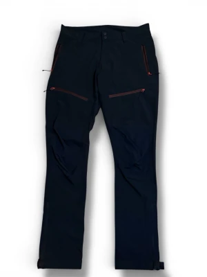 Svarta Everest friluftsbyxor - Snygga svarta täckbyxor med flera dragkedjeförsedda fickor och justerbara benslut. Byxorna har en stilren design och är perfekta för kalla dagar. Materialet är slitstarkt och passar för utomhusaktiviteter.