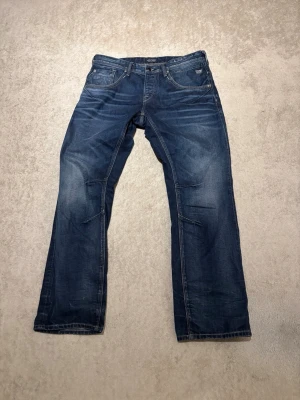 Blå jeans från Jack and Jones  - Säljer ett par klassiska blå jeans från Jack and Jones med raka ben och fem fickor. Jeansen är galet archive och en tvättad look som ger en avslappnad stil. Tillverkade i denim med detaljerade sömmar och logotyp på fickan. Du kommer vara mest archive av dom alla! Pris kan självklart diskuteras 