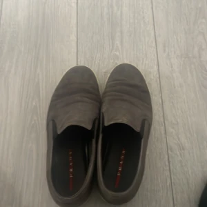 Bruna loafers från Prada dom är äkta  - Snygga bruna loafers från Prada i skinn. De har en stilren design med en diskret logga på insidan. Perfekta för en elegant look.