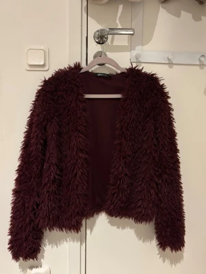 Vinröd päls jacka - Vinröd tunn päls jacka, perfekt för vår och sommar. Super söt!!