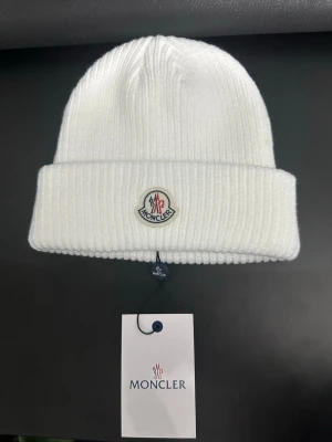 Moncler mössa (beanie) - Klassisk vit moncler mössa med etiketten på. Priset kan diskuteras, kontakta över funderingar 🤩
