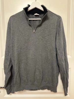 Halvzip tröja från John Henric - Snygg grå tröja från John Henric med halvzip och hög krage. Perfekt för lager på lager. Svart insida på kragen ger en stilren kontrast. 