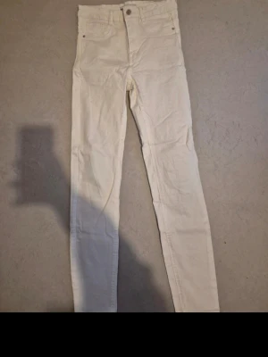 Vita skinny jeans - Snygga vita skinny jeans från Gina Tricot med klassisk femficksdesign och hög midja. Jeansen är i ett stretchigt material som sitter tajt längs benen och har knapp- och dragkedjestängning framtill.