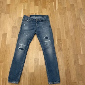 Dondup George - Tja! Säljer mina fina dondup George. Storlek 34 vilket ungefär är W31/ L32. Jeansen är superfina. Det bläckliknande färgen på baksidan av fickan är en del av designen. Hör av dig vid minsta fråga eller fundering. Det saknas en liten bältes hål men det gör inget.