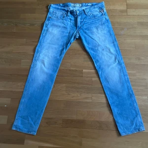 Ljusblåa replay jeans - Säljer ett par ljusblå replay jeans med rak passform och klassisk femficksdesign. Jeansen har slitningar och tvättade detaljer för en avslappnad look. Perfekta för dig som gillar en casual stil och vill ha ett par bekväma jeans i garderoben. W36 L34