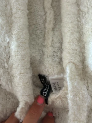 Krämvit hoodie från hm - Mysig krämvit hoodie från Issue med fluffig, texturerad yta och justerbar huva med dragsko. Hoodien har långa ärmar och är tillverkad i ett mjukt, teddy-liknande material som känns riktigt skönt mot huden. Perfekt för dig som gillar en chill och avslappnad stil.