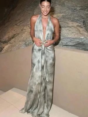 Balklänning långklänning med knyt - Snygg långklänning i silvrig nyans med djup v-ringning och knyt i midjan. Klänningen har ärmlös design och ett elegant, flytande material som ger en lyxig känsla. Perfekt för dig som vill sticka ut med stil.