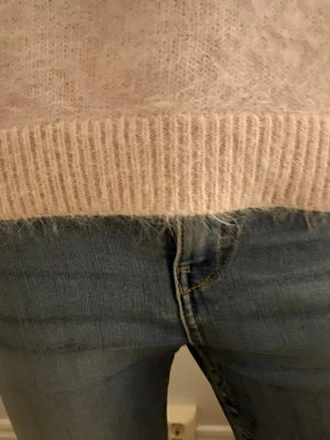 Blå slitna jeans Kappahl  - Säljer ett par blå jeans från Kappahl med snygga slitningar och klassisk femficksmodell. Jeansen har normalhög midja och guldfärgade sömmar. Perfekta till en avslappnad stil och passar till det mesta i garderoben.