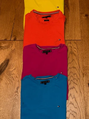 Färgglada T-shirts från Tommy Hilfiger - Fyra stilrena T-shirts från Tommy Hilfiger i färgerna blå, rosa, orange och gul. Passformen är extra slim fit strl M. 200kr styck. Alla tröjor för 650