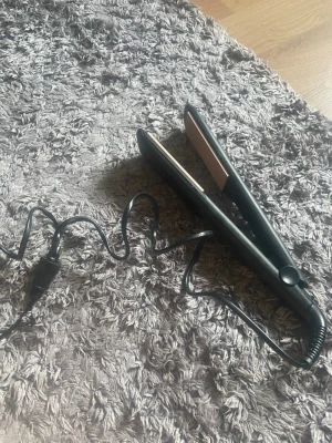 Svart våffeltång från Remington - Säljer en svart våffeltång från Remington med räfflade keramiska plattor. Perfekt för att skapa volym och våfflade effekter i håret. Tången har sladd och enkel knapp för att slå på och av. Smidig design som är lätt att använda.