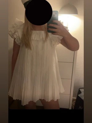 Vit plisserad Zara klänning - Säljer denna populära Zara klänning.  Perfekt inför studenten!! 🥰 OBS se fläck på bild 4, dock inget som syns eftersom den är plisserad, går säkert bort i tvätten!! 