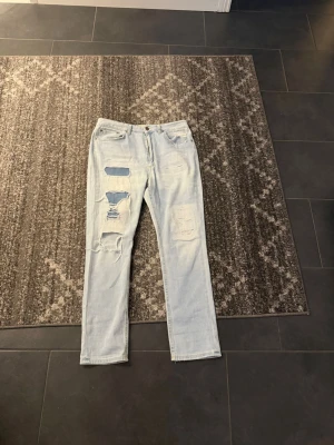 Dondup jeans ljusblå - Säljer ett par ljusblå jeans med straight fit och slitna detaljer på framsidan. Jeansen har klassisk femficksdesign och patch bak i midjan. Perfekta för en avslappnad och trendig look. NYPRIS 2000kr. Tveka inte på höra av dig 