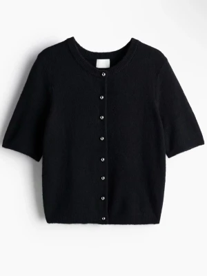 Svart kortärmad kofta med pärlknappar - Stilren svart kofta med korta ärmar och pärlknappar framtill. Koftan har rund halsringning och är stickad i ett mjukt material. Perfekt att slänga över en topp för en enkel men snygg look. Köpt från H&M, helt oanvänd🩶