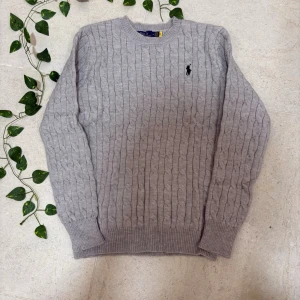 Polo Ralph Lauren Knit - Brand new Polo Ralph Lauren cable knit sweater for sale. Perfect for autumn and winter wear. Classic black shade with the iconic embroidered logo on the chest 🐎.(Ask for measurements.)  🔹 Brand: Polo Ralph Lauren 🔹 Color: Grey 🔹 Model: Cable knit, long-sleeved 🔹 Condition: Brand new with tags ✨ 🔹 Size: M  Perfect for a clean, smart, and polished look 👌 📦 Fast shipping | 💬 Feel free to ask for more information