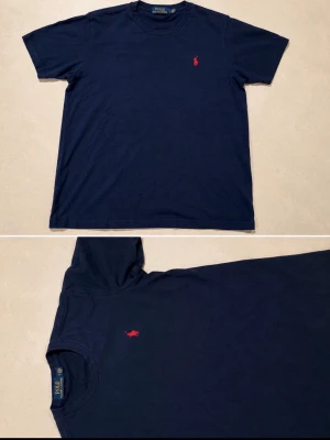 Marinblå t-shirt från Polo Ralph Lauren - Klassisk marinblå t-shirt från Polo Ralph Lauren med röd broderad logga på bröstet. T-shirten har rund halsringning och korta ärmar. Tillverkad i mjuk bomull för en bekväm känsla och stilren look.